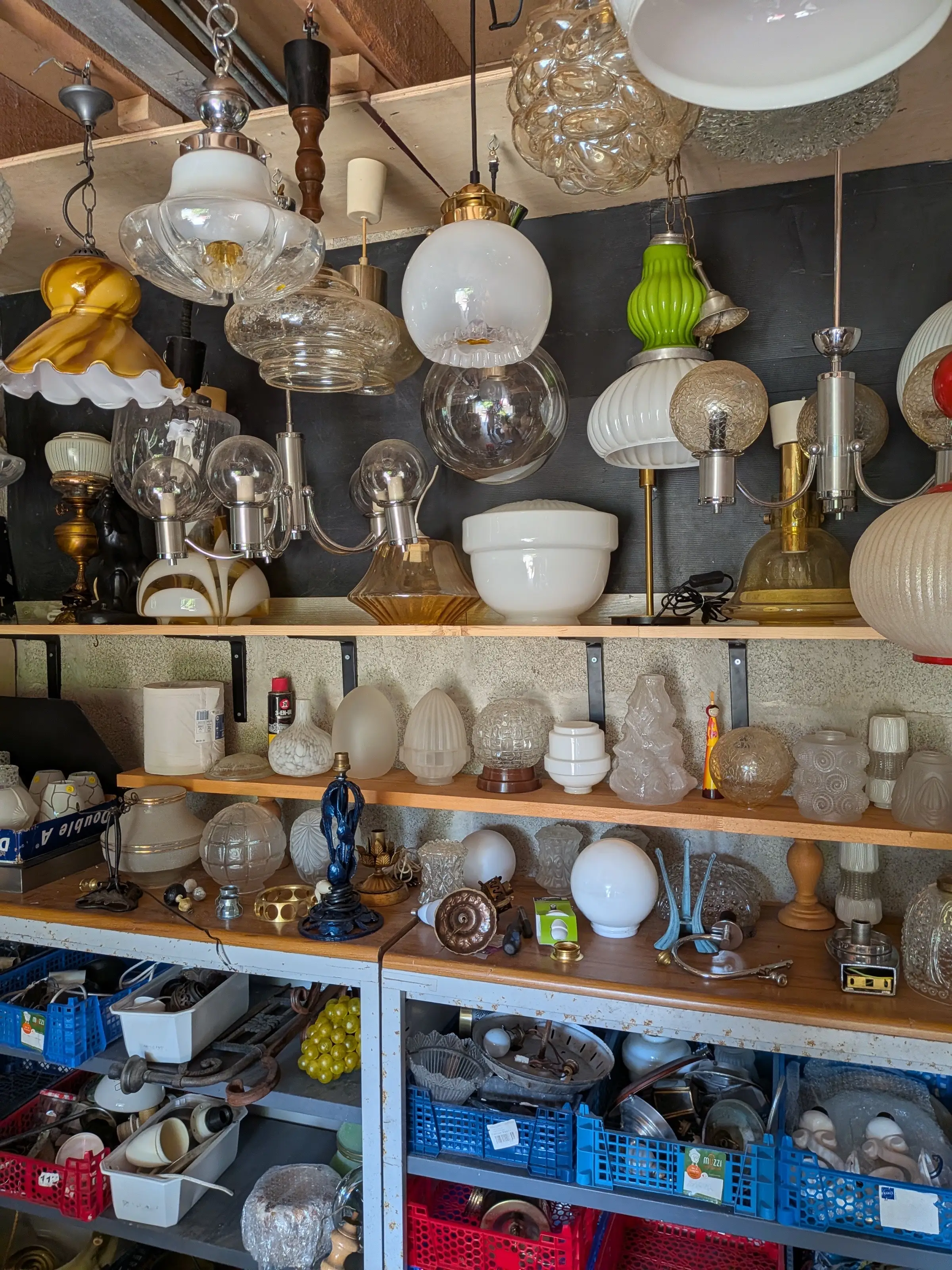 Des étagères de globes et d’abat-jour en verre, dans le garage